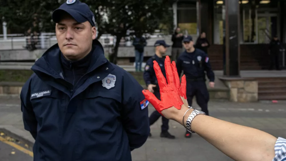 A demonstrator shows her hand painted in red to a member of police as demonstrators protest to commemorate an accident at a railway station in the Serbian city of Novi Sad, for which they blame negligence and corruption by the authorities, in front of the government in Belgrade, Serbia November 3, 2024. REUTERS/Marko Djurica