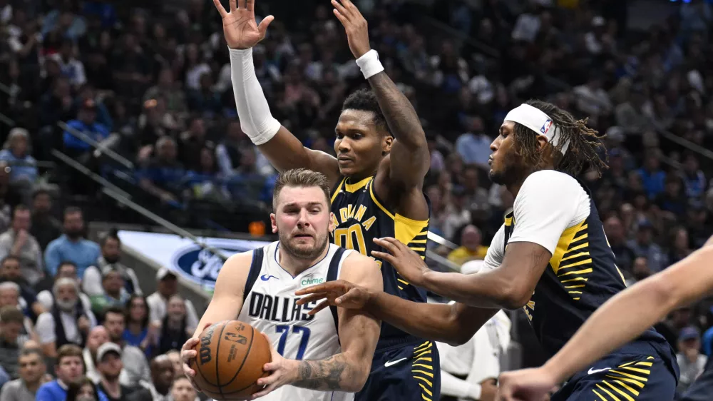 Nov 4, 2024; Dallas, Texas, USA; Dallas Mavericks guard Luka Doncic (77) drives to the basket between Indiana Pacers guard Bennedict Mathurin (00) and center Myles Turner (33) during the second half at the American Airlines Center. Mandatory Credit: Jerome Miron-Imagn Images