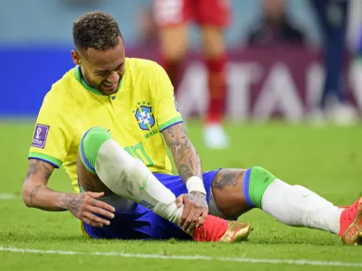 Brazil's Neymar grabs his ankle after an injury during the World Cup group G soccer match between Brazil and Serbia, at the the Lusail Stadium in Lusail, Qatar on Thursday, Nov. 24, 2022. (Laurent Gillieron/Keystone via AP)