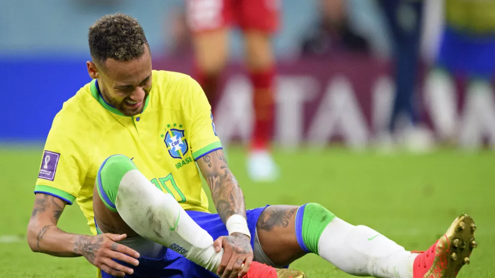 Brazil's Neymar grabs his ankle after an injury during the World Cup group G soccer match between Brazil and Serbia, at the the Lusail Stadium in Lusail, Qatar on Thursday, Nov. 24, 2022. (Laurent Gillieron/Keystone via AP)