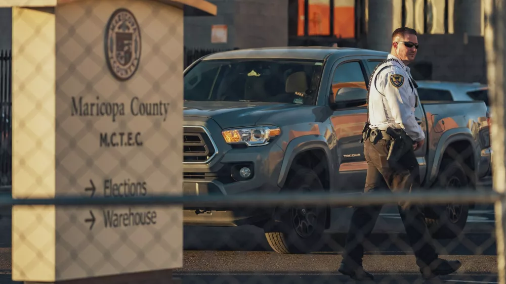 A security guard stands behind a fence at the Maricopa County Election and Tabulation Center in Phoenix, Arizona, on November 4, 2024. Concrete barriers, high wire fences and armed agents inside: on the eve of the American presidential election, the election center in Phoenix, Arizona, looks like a fortress.,Image: 930510399, License: Rights-managed, Restrictions: TO GO WITH AFP STORY by Romain FONSEGRIVES: "Conspiracy theory ground zero: Arizona plots trouble-free polling", Model Release: no