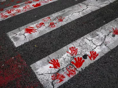 Demonstrators leave red hand prints on a crosswalk as they protest to commemorate an accident at a railway station in the Serbian city of Novi Sad, for which they blame negligence and corruption by the authorities, in front of the government in Belgrade, Serbia November 3, 2024. REUTERS/Marko Djurica