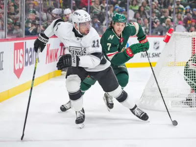 Nov 5, 2024; Saint Paul, Minnesota, USA; Los Angeles Kings center Anze Kopitar (11) skates after the puck against the Minnesota Wild defenseman Brock Faber (7) in the first period at Xcel Energy Center. Mandatory Credit: Brad Rempel-Imagn Images