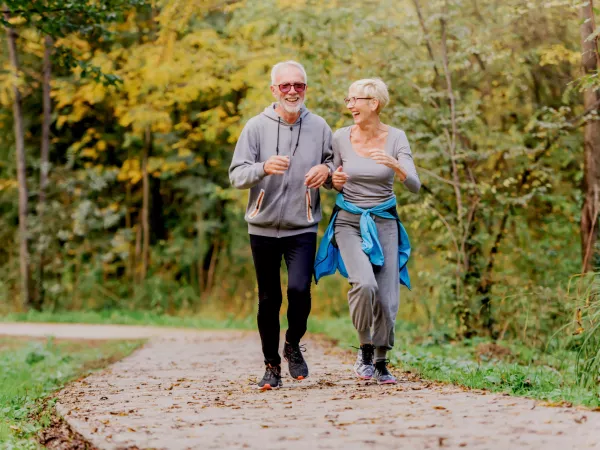 Smiling senior couple jogging in the park