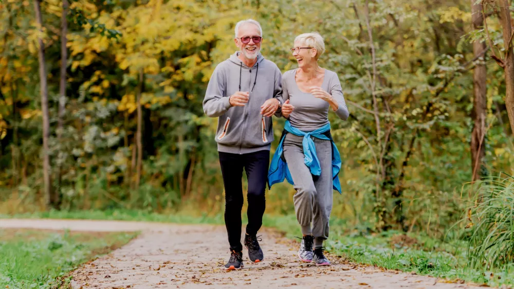 Smiling senior couple jogging in the park