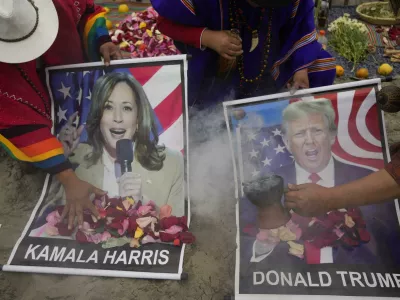 Shamans perform a good luck ritual holding posters of Democratic presidential nominee Vice President Kamala Harris and Republican presidential nominee former President Donald Trump, at the beach in Lima, Peru, Tuesday, Nov. 5, 2024. (AP Photo/Martin Mejia)