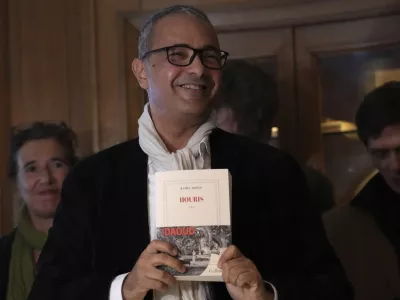 Algerian-French novelist Kamel Daoud holds his book Houris after being awarded with the Goncourt, France's most prestigious literary prize, Monday, Nov. 4, 2024 in Paris. (AP Photo/Aurelien Morissard)