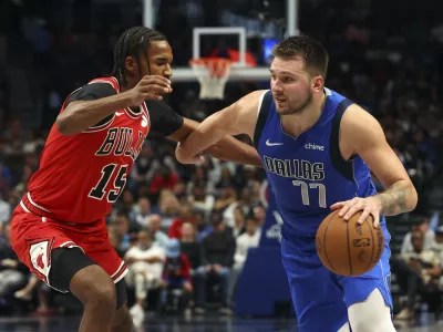 Chicago Bulls forward Julian Phillips (15) defends as Dallas Mavericks guard Luka Doncic (77) drives the ball past in the second half of an NBA basketball game Wednesday, Nov. 6, 2024, in Dallas. (AP Photo/Richard W. Rodriguez)