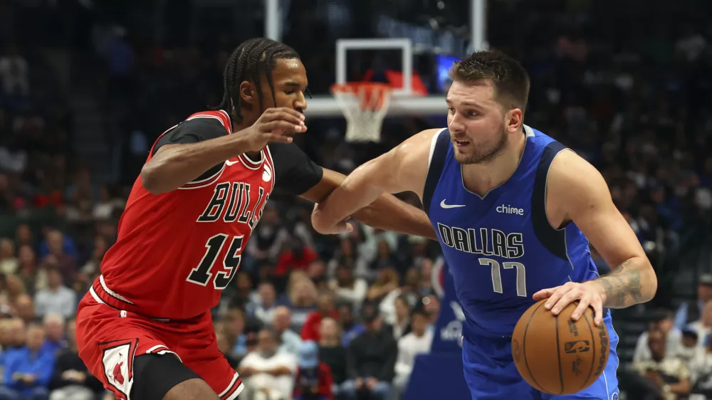 Chicago Bulls forward Julian Phillips (15) defends as Dallas Mavericks guard Luka Doncic (77) drives the ball past in the second half of an NBA basketball game Wednesday, Nov. 6, 2024, in Dallas. (AP Photo/Richard W. Rodriguez)