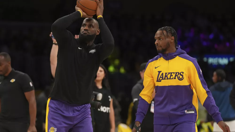 Los Angeles Lakers forward LeBron James, left, and guard Bronny James warm up before an NBA basketball game against the Minnesota Timberwolves, Tuesday, Oct. 22, 2024, in Los Angeles. (AP Photo/Eric Thayer)