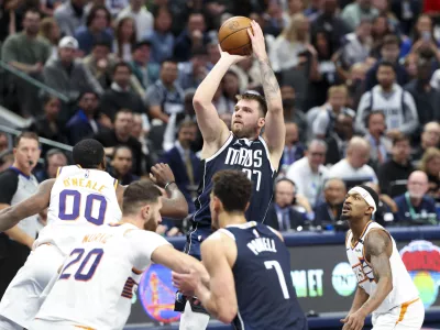 Nov 8, 2024; Dallas, Texas, USA; Dallas Mavericks guard Luka Doncic (77) shoots over Phoenix Suns forward Royce O'Neale (00) during the fourth quarter at American Airlines Center. Mandatory Credit: Kevin Jairaj-Imagn Images