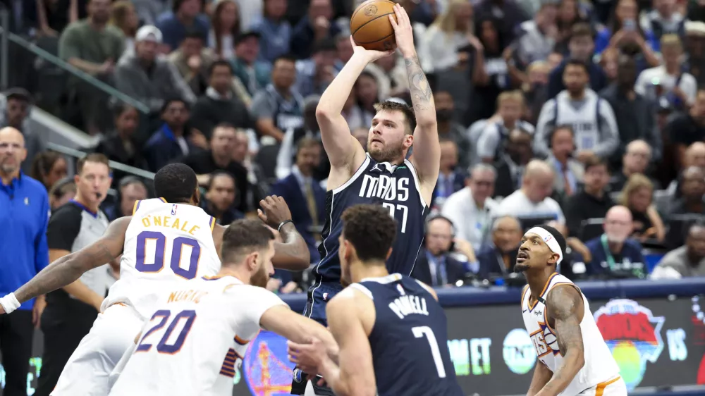 Nov 8, 2024; Dallas, Texas, USA; Dallas Mavericks guard Luka Doncic (77) shoots over Phoenix Suns forward Royce O'Neale (00) during the fourth quarter at American Airlines Center. Mandatory Credit: Kevin Jairaj-Imagn Images