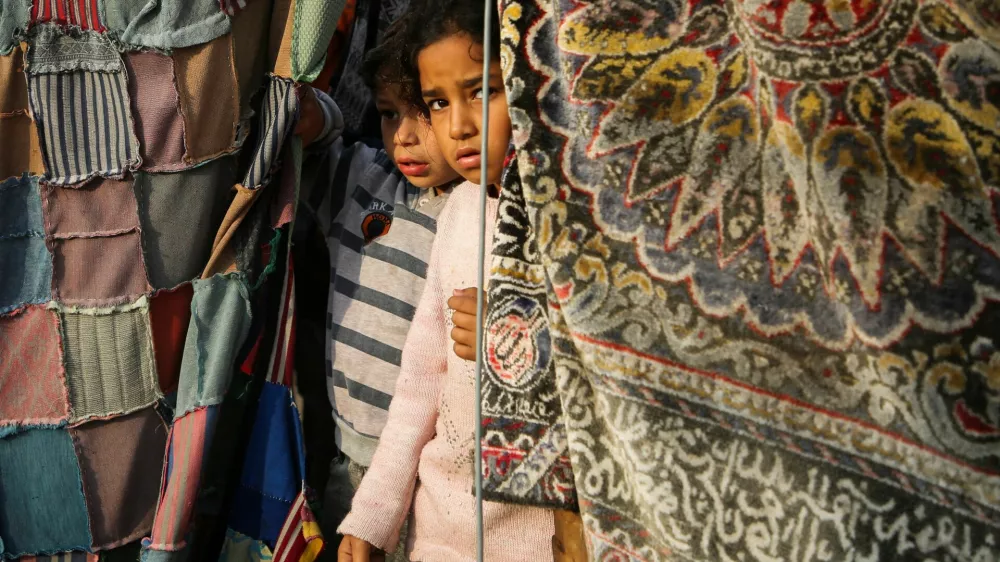 Palestinian children stand at the site of an Israeli strike on a tent housing displaced people, in Khan Younis in the southern Gaza Strip November 9, 2024. REUTERS/Hatem Khaled