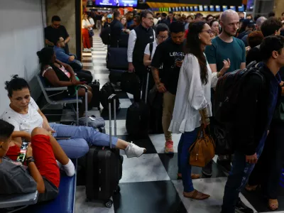 People sit as others queue to rebook a flight at the check in sector after flights were canceled due heavy rains at Congonhas Airport in Sao Paulo, Brazil November 8, 2024. REUTERS/Amanda Perobelli