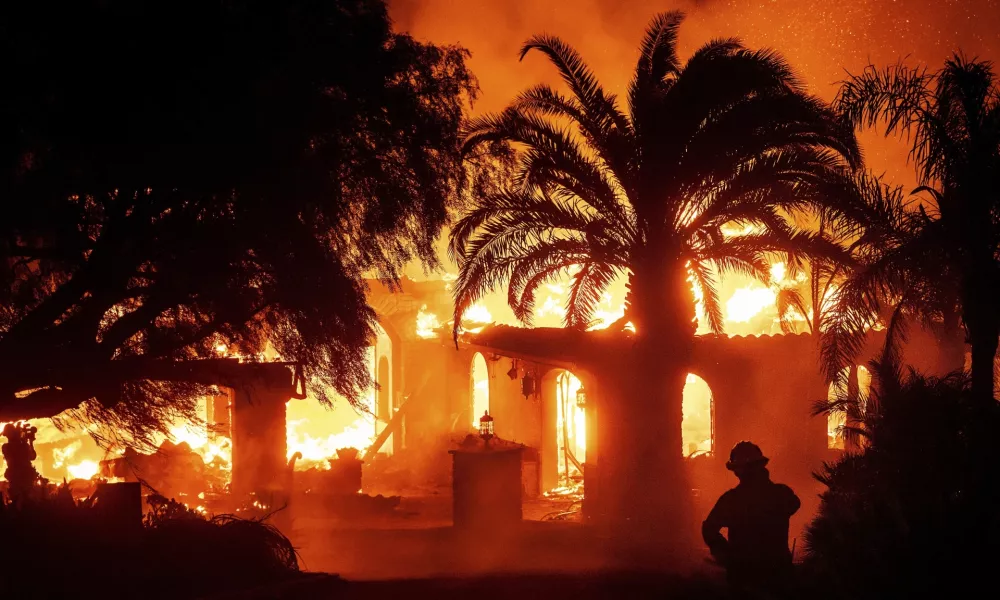 A firefighter watches as flames from the Mountain Fire consume a home in Camarillo, Calif., Nov. 6, 2024. (AP Photo/Noah Berger)