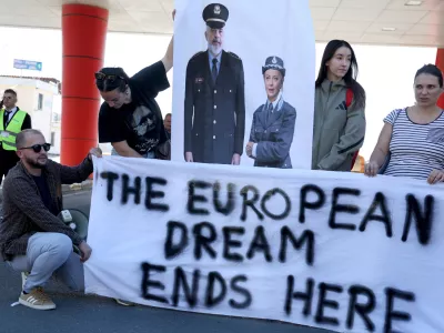 Activists holds a poster depicting Albanian Prime Minister Edi Rama and Italian Prime Minister Giorgia Meloni during a protest on the day migrants arrive on Italian navy ship Libra in Albania as part of a deal with Italy to process thousands of asylum-seekers caught near Italian waters, in Shengjin, Albania, October 16, 2024. REUTERS/Florion Goga