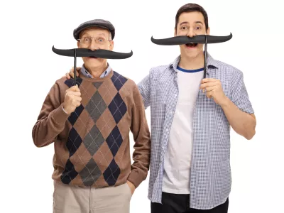 Senior and a young man posing with big fake moustaches isolated on white background / Foto: Ljupco