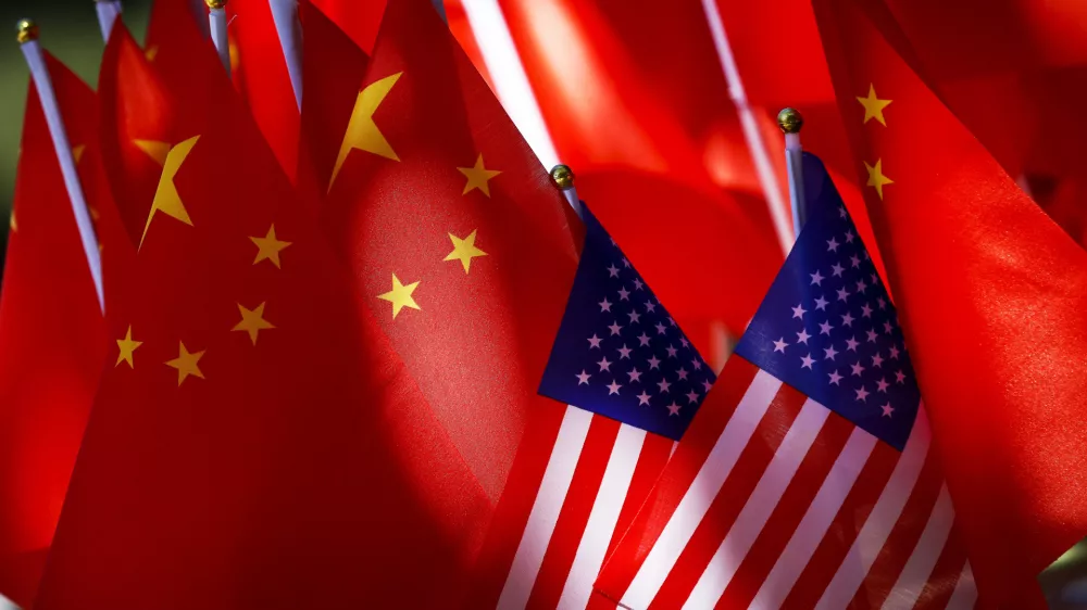 ﻿In this Sept. 16, 2018, photo, American flags are displayed together with Chinese flags on top of a trishaw in Beijing. The American Chamber of Commerce in China says Beijing will "dig its heels in" after U.S. tariff hikes and appealed for a negotiated end to their trade battle. The chamber on Tuesday, Sept. 18 warned a "downward spiral" appears certain after President Donald Trump approved a tariff hike on $200 billion of Chinese imports in a dispute over Beijing's technology policy. (AP Photo/Andy Wong)