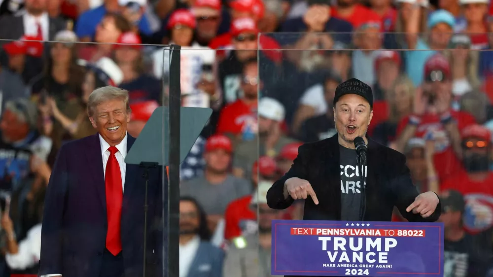 FILE PHOTO: Tesla CEO and X owner Elon Musk speaks as Republican presidential nominee and former U.S. president Donald Trump reacts during a rally at the site of the July assassination attempt against Trump, in Butler, Pennsylvania, U.S., October 5, 2024. REUTERS/Carlos Barria/File Photo