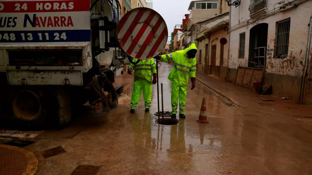 Workers clean a drainage system blocked by mud following catastrophic flooding, as Spain braces for torrential rain, in Paiporta, Valencia, November 13, 2024. REUTERS/Vincent West