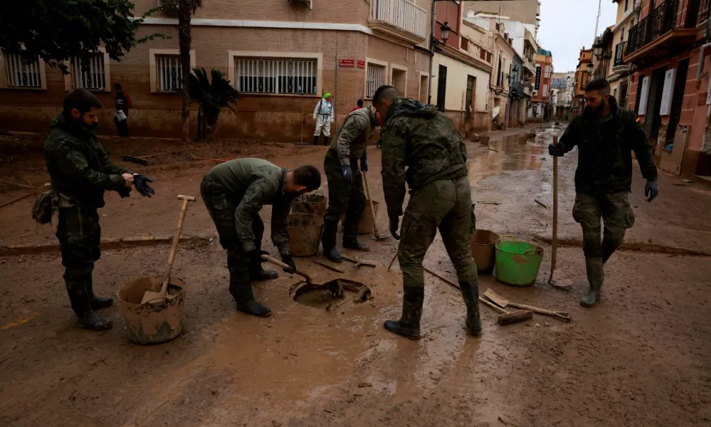 Army personnel clean a drainage system blocked by mud following catastrophic flooding, as Spain braces for torrential rain, in Paiporta, Valencia, November 13, 2024. REUTERS/Vincent West