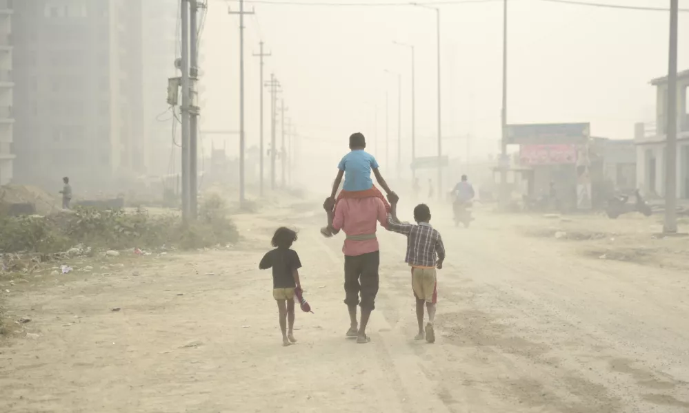 ﻿A village man walks carrying a child on his shoulders on a foggy day in Greater Noida, near New Delhi, India, Monday, Nov.5, 2018. With air quality reduced to "very severe" in the Indian capital region, authorities are bracing for a major Hindu festival featuring massive fireworks that threatens to cloak New Delhi with more toxic smog and dust. (AP Photo/R S Iyer)