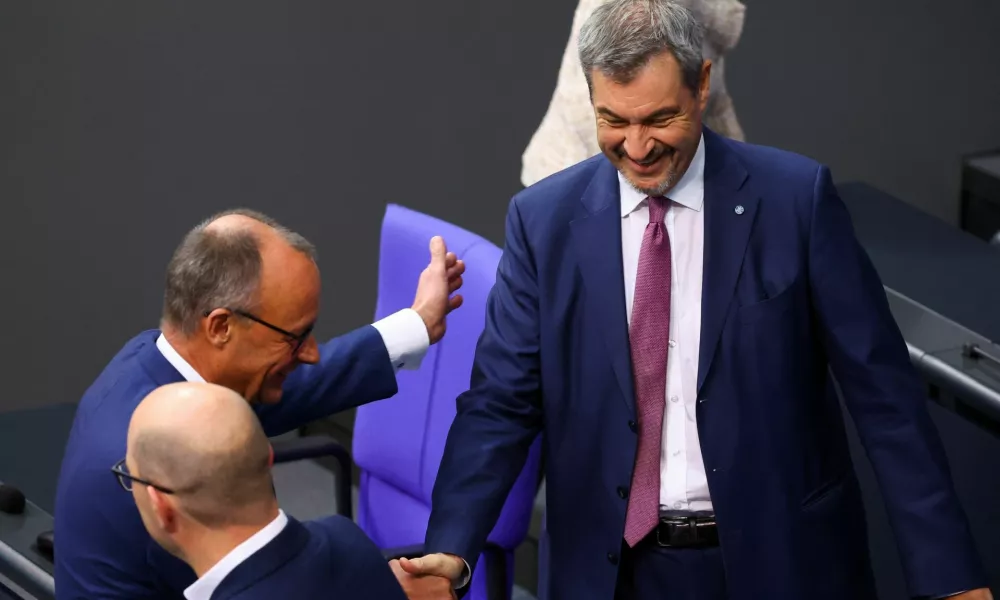 German opposition leader Friedrich Merz of the Christian Democratic Union party (CDU) and Bavarian State Prime Minister Markus Soeder of the Christian Social Union (CSU) shake hands at the lower house of parliament, the Bundestag, in Berlin, Germany November 13, 2024. REUTERS/Lisi Niesner