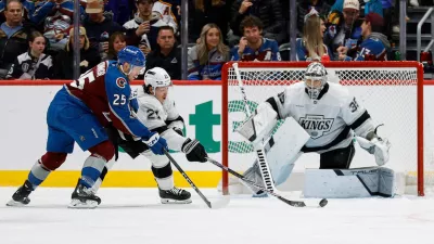 Nov 13, 2024; Denver, Colorado, USA; Los Angeles Kings defenseman Jordan Spence (21) clears the puck against Colorado Avalanche right wing Logan O'Connor (25) ahead of goaltender Darcy Kuemper (35) in the third period at Ball Arena. Mandatory Credit: Isaiah J. Downing-Imagn Images