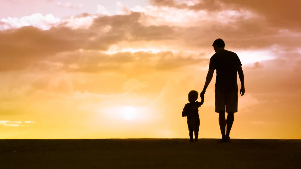 Loving father walking side by side with son holding hands. / Foto: Kieferpix