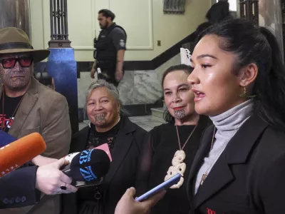 Hana-Rawhiti Maipi-Clarke, right, and her colleagues from Te Haiti Māori, talk to reporters following a protest inside Parliament in Wellington, New Zealand, Thursday, Nov. 14, 2024. (AP Photo/Charlotte Graham-McLay)