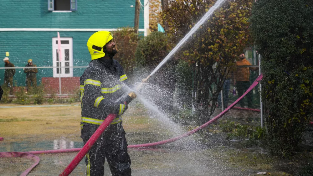 An Indian firefighter works to extinguish a fire on a school building in Srinagar, Indian controlled Kashmir, Thursday, Nov 14, 2024. (AP Photo/Mukhtar Khan)