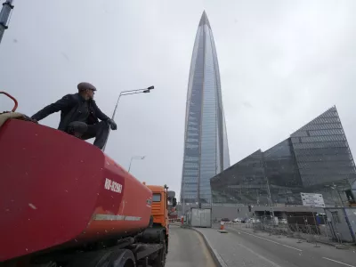 FILE - A worker sits on his water tank truck next to the business tower Lakhta Centre, the headquarters of Russian gas monopoly Gazprom in St. Petersburg, Russia, April 27, 2022. (AP Photo/Dmitri Lovetsky, File)