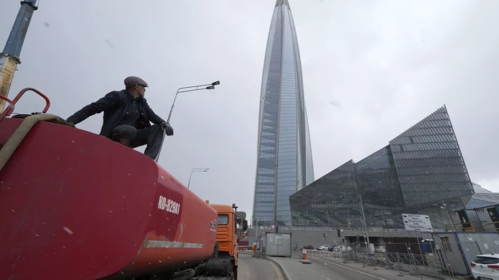 FILE - A worker sits on his water tank truck next to the business tower Lakhta Centre, the headquarters of Russian gas monopoly Gazprom in St. Petersburg, Russia, April 27, 2022. (AP Photo/Dmitri Lovetsky, File)