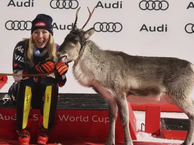 The winner United States' Mikaela Shiffrin shares the podium with a baby reindeer after an alpine ski, women's World Cup slalom, in Levi, Finland, Saturday, Nov. 16, 2024. (AP Photo/Marco Trovati)