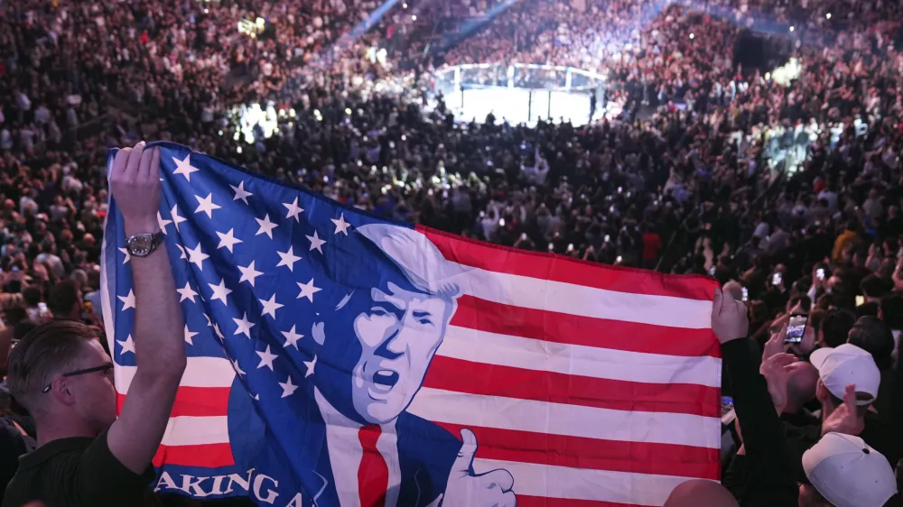 People hold a flag as President-elect Donald Trump arrives at UFC 309 at Madison Square Garden, Saturday, Nov. 16, 2024, in New York. (AP Photo/Evan Vucci)