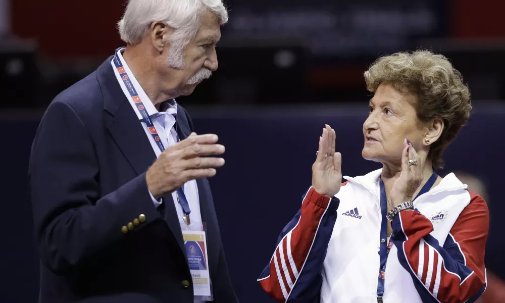 FILE - Bela Karolyi, left, and his wife, Martha Karolyi, talk on the arena floor before the start of the preliminary round of the women's Olympic gymnastics trials in San Jose, Calif., June 29, 2012. (AP Photo/Gregory Bull, File)