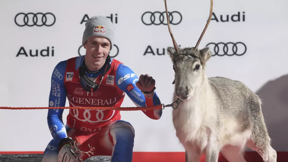 The winner France's Clement Noel celebrates on podium with a young reindeer after an alpine ski, men's World Cup slalom, in Levi, Finland, Sunday, Nov. 17, 2024. (AP Photo/Marco Trovati)