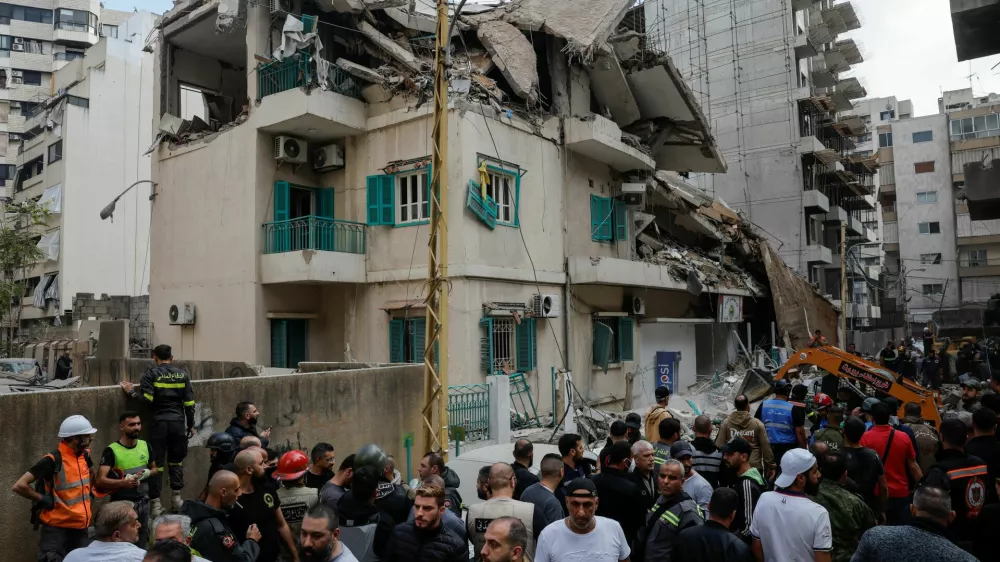 People and rescuers gather at the site of an Israeli strike on a building that according to security sources killed Hezbollah's media relations chief Mohammad Afif in Ras Al- Nabaa, in Beirut, Lebanon November 17, 2024. REUTERS/Adnan Abidi