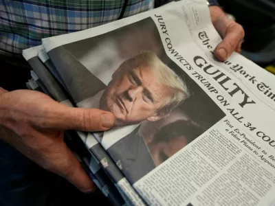 A person holds New York Times newspapers, as they are being printed, following the announcement of the verdict on former U.S. President Donald Trump's criminal trial, over charges that he falsified business records to conceal money paid to silence adult film star Stormy Daniels in 2016, at the New York Times College Point Printing Plant in Queens, New York City, U.S. May 30, 2024. REUTERS/Stephani Spindel   TPX IMAGES OF THE DAY