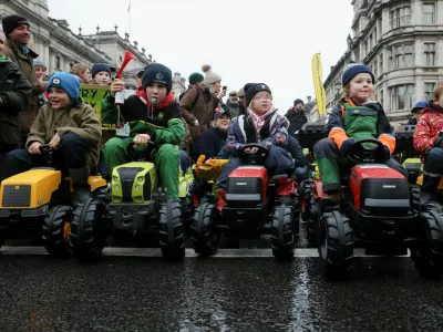 Children sit in toy tractors, as farmers protest against the Labour government's new agricultural policy, which includes a budget measure expected to increase inheritance tax liabilities for some farmers, in London, Britain, November 19, 2024. REUTERS/Mina Kim