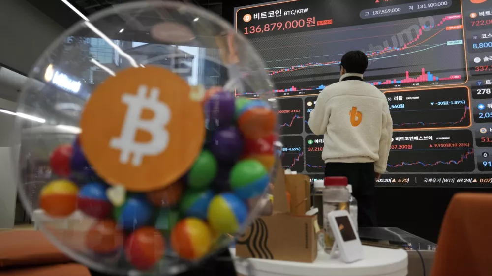 An employee watches an electronic signboard displaying the prices of Bitcoin and other cryptocurrencies at the lounge of Bithumb cryptocurrency exchange in Seoul, South Korea, Thursday, Nov. 21, 2024. (AP Photo/Ahn Young-joon)