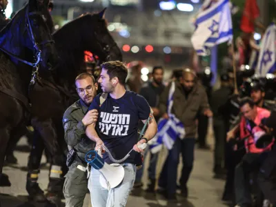 15 April 2023, Israel, Tel Aviv: Israeli police officers arrest a protester during a protest against plans by Prime Minister Benjamin Netanyahu's government to overhaul the judicial system. Photo: Ilia Yefimovich/dpa