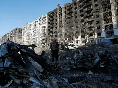 FILE PHOTO: Local resident and mechanic Vadim Tarasenko, 56, stands next to the wreckage of his car in the courtyard of an apartment building destroyed in the course of Ukraine-Russia conflict in the besieged southern port city of Mariupol, Ukraine March 28, 2022. REUTERS/Alexander Ermochenko/File Photo