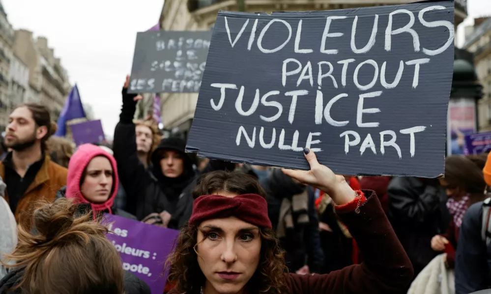 A woman holds a placard as people attend a demonstration to protest against femicide, sexual violence and all gender-based violence to mark the International Day for Elimination of Violence Against Women, in Paris, France, November 23, 2024. The placard reads: "Rapists everywhere justice nowhere". REUTERS/Abdul Saboor