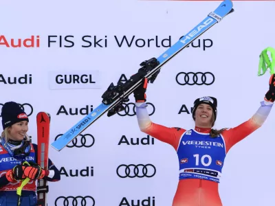 United States' Mikaela Shiffrin, left, winner of an alpine ski, women's World Cup slalom, looks at third-placed Switzerland's Camille Rast celebrating, right, in Gurgl, Austria, Saturday, Nov. 23, 2024. (AP Photo/Giovanni Maria Pizzato)