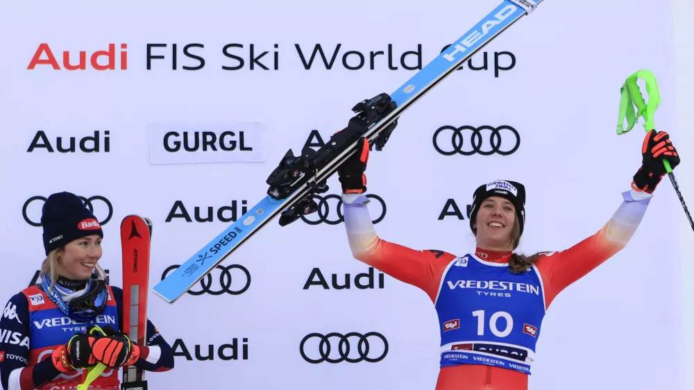 United States' Mikaela Shiffrin, left, winner of an alpine ski, women's World Cup slalom, looks at third-placed Switzerland's Camille Rast celebrating, right, in Gurgl, Austria, Saturday, Nov. 23, 2024. (AP Photo/Giovanni Maria Pizzato)