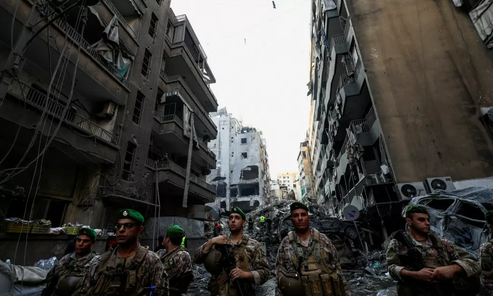 Civil defense members work as Lebanese army soldiers stand guard at the site of an Israeli strike in Beirut's Basta neighbourhood, amid the ongoing hostilities between Hezbollah and Israeli forces, Lebanon November 23, 2024. REUTERS/Thaier Al-Sudani