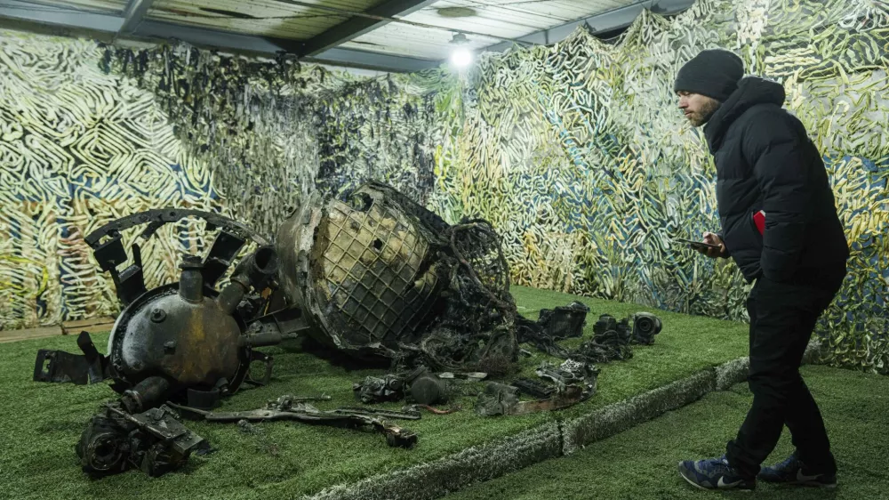 A journalist looks on fragments of a rocket which struck Dnipro on November 21, at a center for forensic analysis in undisclosed location, Ukraine, Sunday Nov. 24, 2024. (AP Photo/Evgeniy Maloletka)