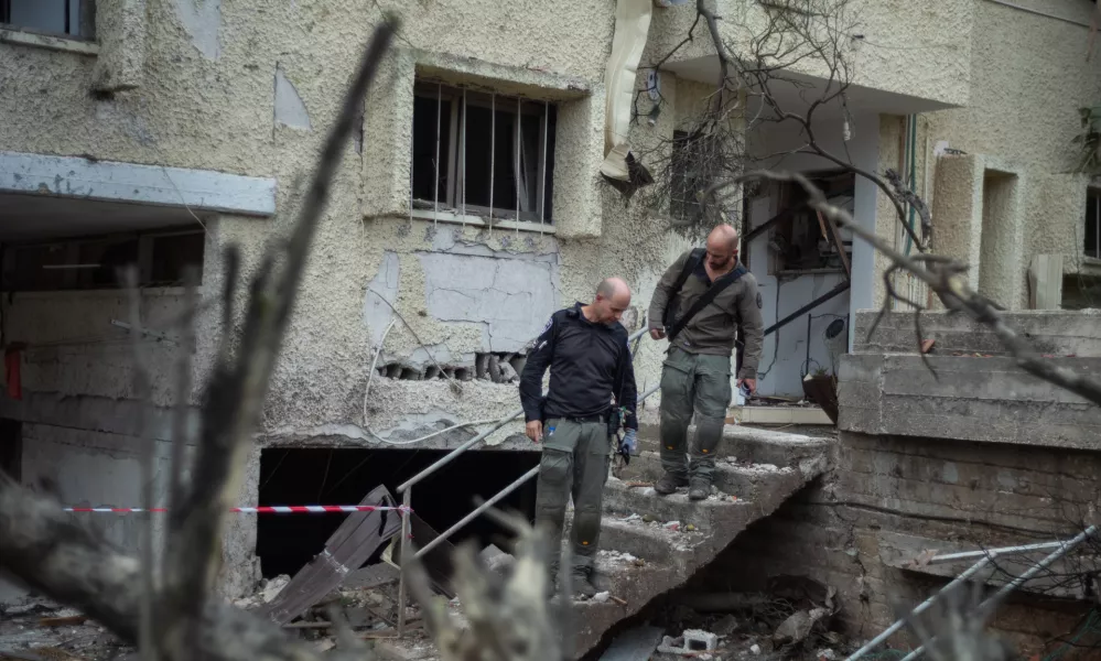 24 November 2024, Israel, Rinatya: Israeli Security personnel inspect the site, where a building was hit by a Hezbollah rocket strike from Lebanon. Photo: Ilia Yefimovich/dpa