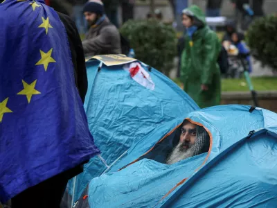 An opposition activist looks out of a tent during a rally to protest against the results of Georgia's parliamentary election, which the opposition say were rigged, as the new parliament holds the first session in Tbilisi, Georgia November 25, 2024. REUTERS/Irakli Gedenidze   TPX IMAGES OF THE DAY